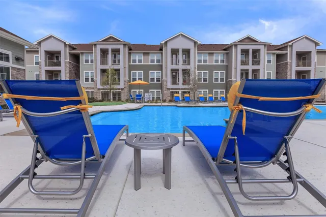 a view of a house with pool and chairs