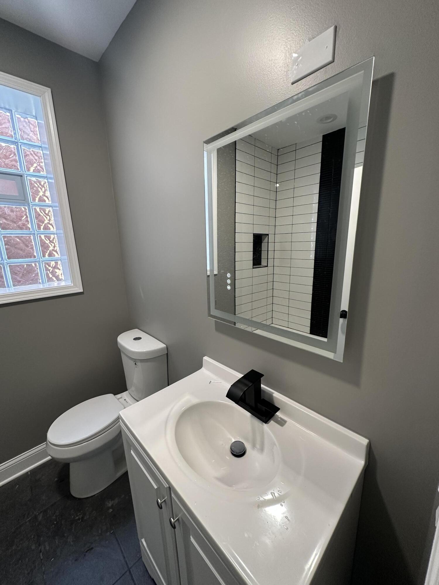 1320 Delaware Street Gary, IN 46407 - Photo 11 of 17 a bathroom with a sink a toilet and mirror