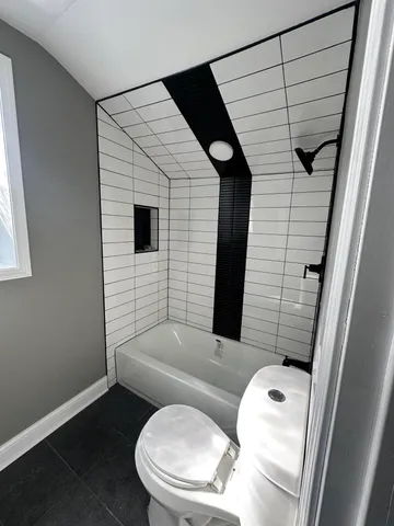 a bathroom with a toilet and a shower