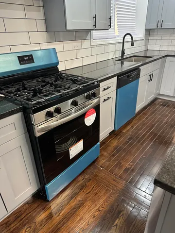 a kitchen with granite countertop a stove and a sink