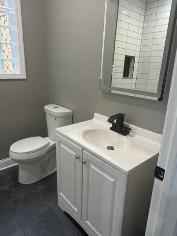 a white toilet sitting next to a bathroom sink