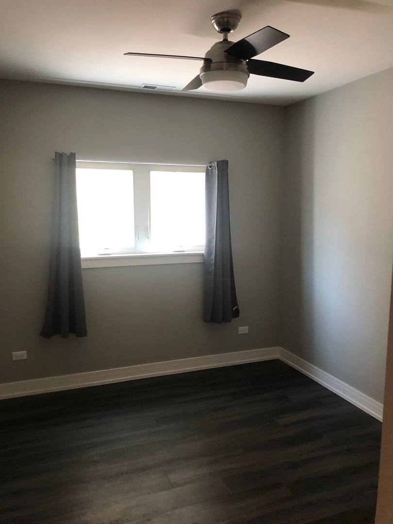 1734 West Cullerton Street, Unit 1 Chicago, IL 60608 - Photo 7 of 12 an empty room with wooden floor and windows