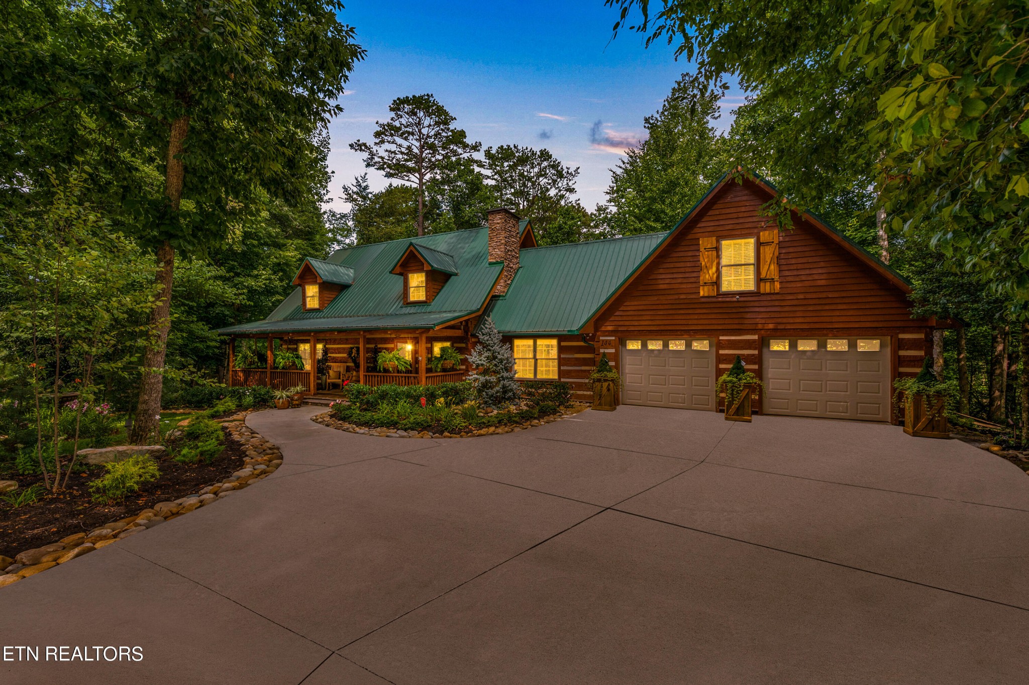 a front view of a house with a yard and potted plants