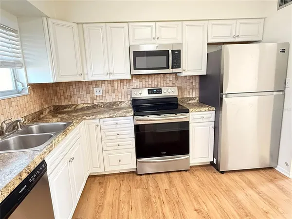 a kitchen with a sink stove and refrigerator