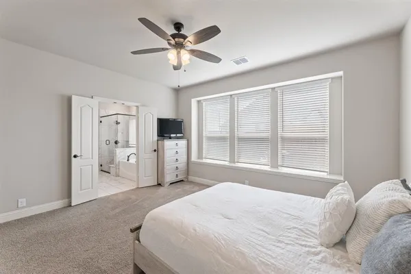 a spacious bedroom with a bed and a chandelier