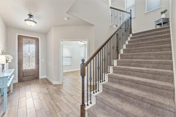 a view of a hallway with wooden floor and staircase
