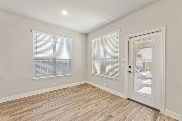 wooden floor in an empty room with a window