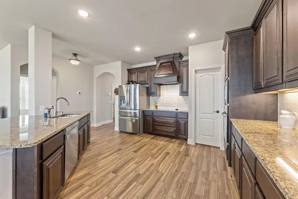a kitchen with stainless steel appliances a sink stove and refrigerator