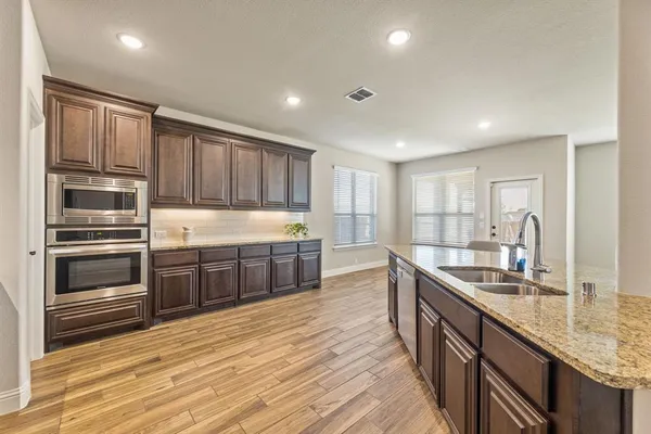 a kitchen with stainless steel appliances granite countertop a sink stove and cabinets