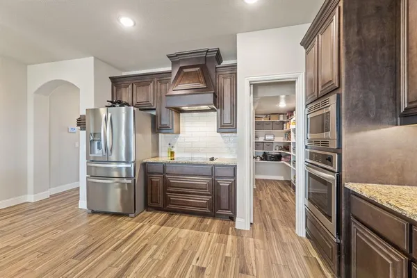 a kitchen with stainless steel appliances a refrigerator and a stove top oven
