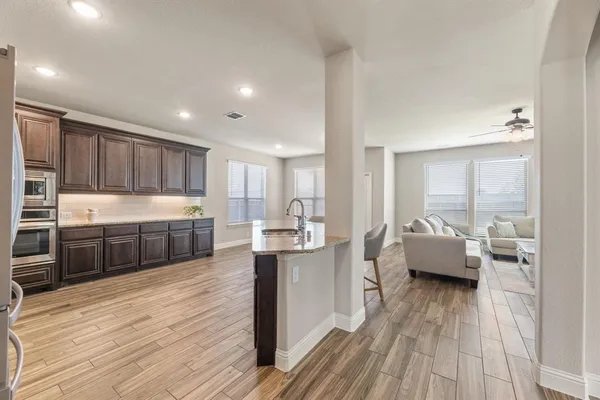 a large kitchen with stainless steel appliances lots of counter top space a sink and cabinets