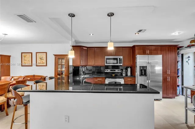 a kitchen with stainless steel appliances granite countertop a sink a stove and a refrigerator