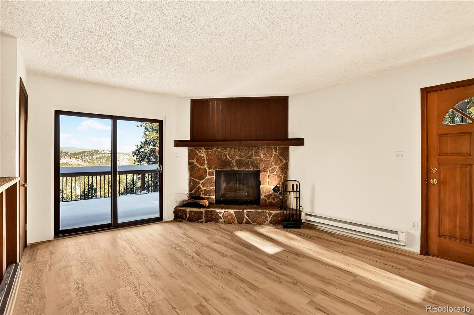 217 Catamount Ridge Road Bailey, CO 80421 - Photo 11 of 37 a living room with a fireplace furniture and a floor to ceiling window