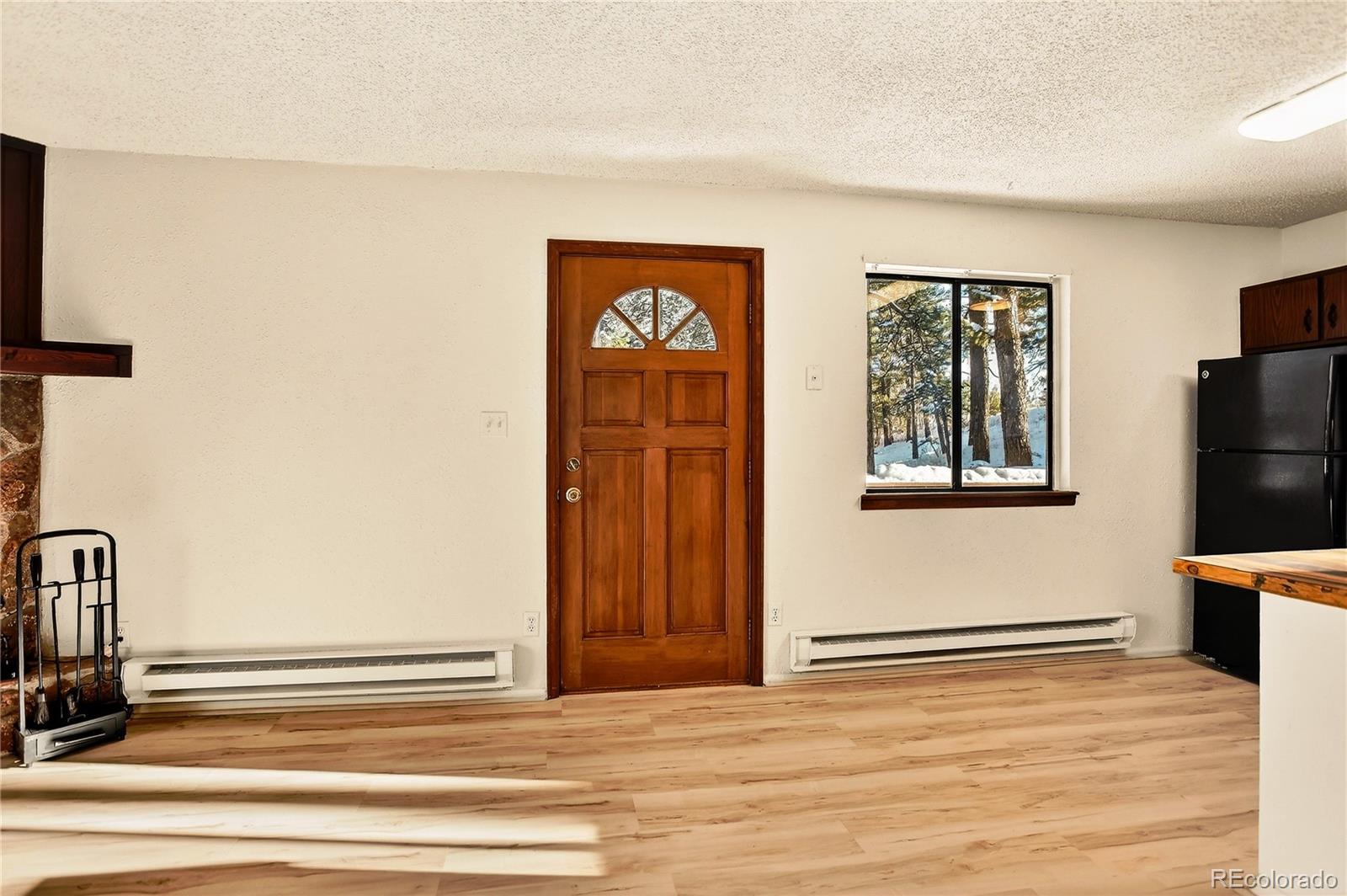 217 Catamount Ridge Road Bailey, CO 80421 - Photo 13 of 37 a view of an empty room with wooden floor and a window