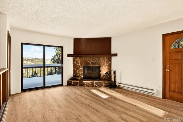 a living room with a fireplace furniture and a floor to ceiling window