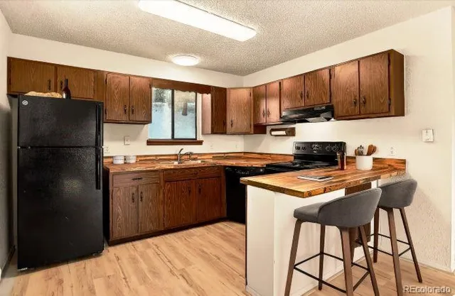 a kitchen with stainless steel appliances granite countertop a refrigerator stove top oven a sink and dishwasher