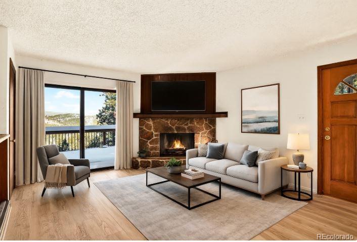 217 Catamount Ridge Road Bailey, CO 80421 - Photo 10 of 37 a living room with furniture a flat screen tv and a fireplace