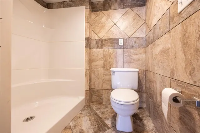 a bathroom with a toilet and a shower