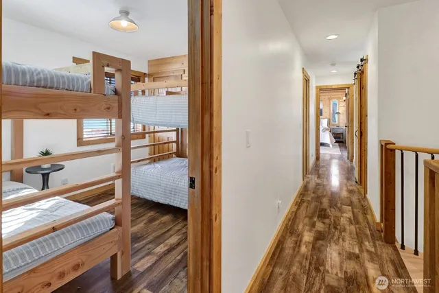a view of a hallway with wooden floor and staircase