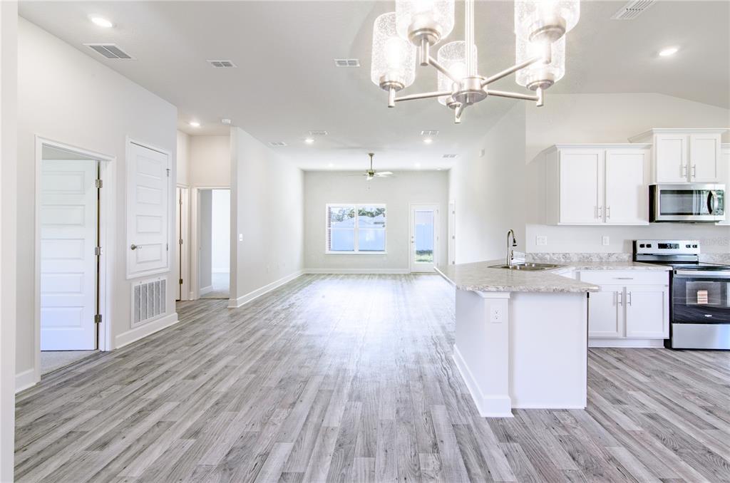 30 Priory Lane Palm Coast, FL 32164 - Photo 6 of 31 a large kitchen with cabinets wooden floor and stainless steel appliances