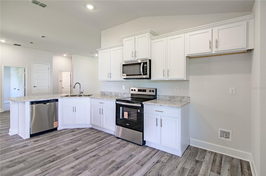 30 Priory Lane Palm Coast, FL 32164 - Photo 9 of 31 a kitchen with granite countertop white cabinets and stainless steel appliances