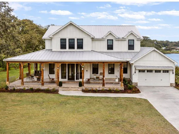 a front view of a house with swimming pool and sitting area