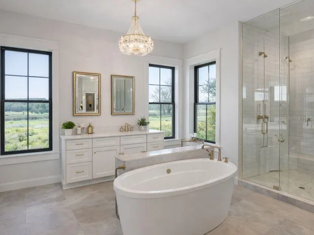 a spacious bathroom with a tub sink shower and mirror