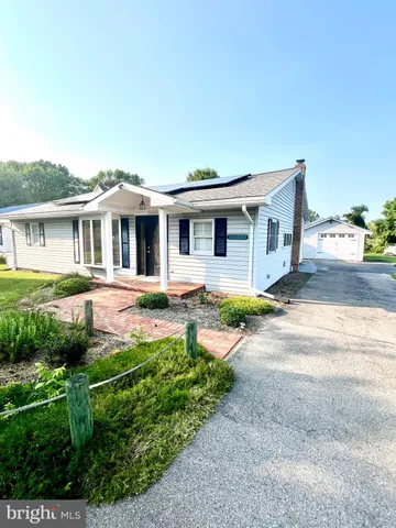 a front view of a house with a yard table and chairs