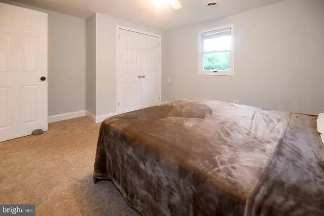 a spacious bedroom with a bed and a chandelier