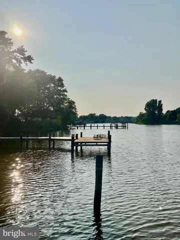 a kitchen with stainless steel appliances a microwave a stove a sink dishwasher a refrigerator white cabinets and wooden floor