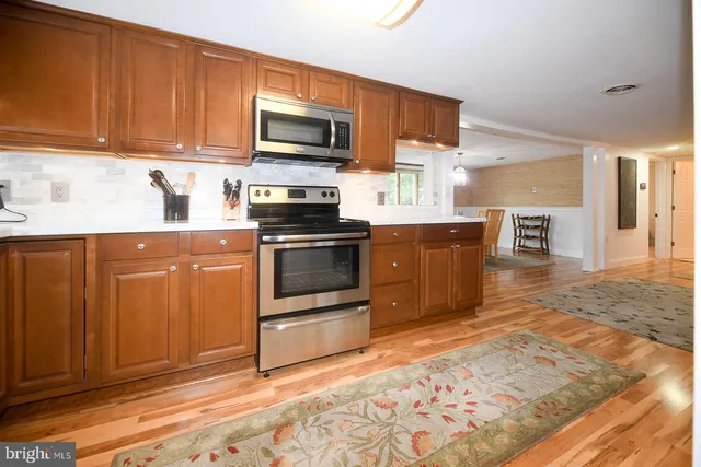 a kitchen with stainless steel appliances granite countertop a stove top oven a sink dishwasher and a microwave oven on the blue kitchen countertops