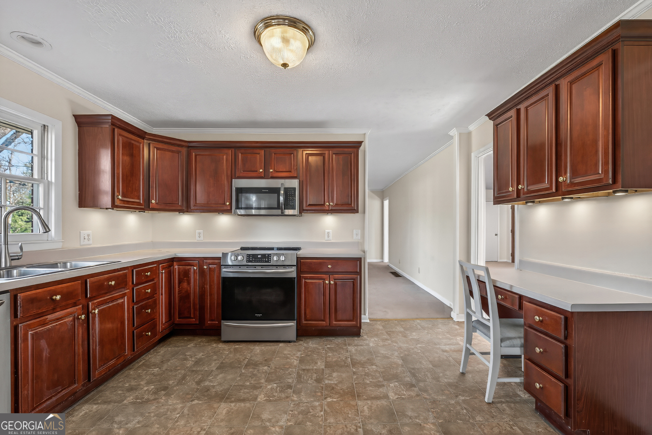 741 East Avenue Madison, GA 30650 - Photo 11 of 40 a kitchen with stainless steel appliances granite countertop a stove and a sink