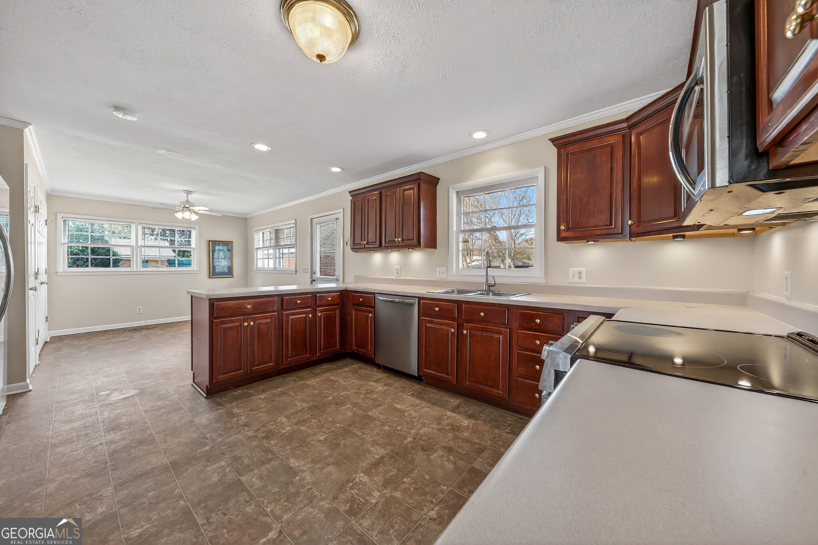 741 East Avenue Madison, GA 30650 - Photo 15 of 40 a kitchen with stainless steel appliances granite countertop a stove sink and cabinets