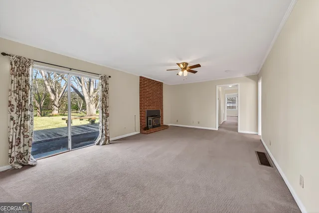an empty room with windows and chandelier fan