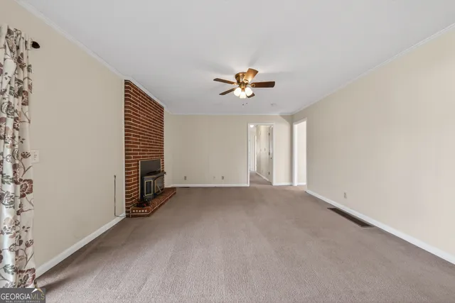 a view of empty room with fireplace and fan