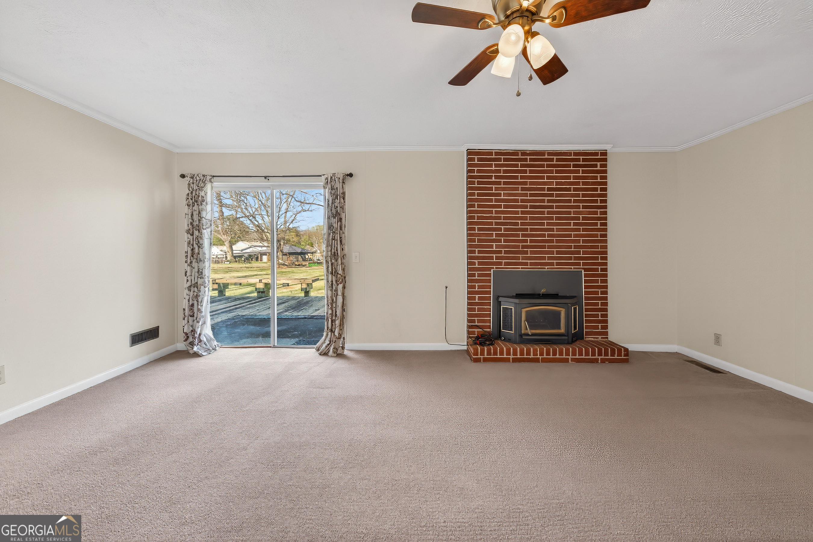 741 East Avenue Madison, GA 30650 - Photo 18 of 40 a view of empty room with fireplace and fan