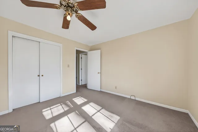 a view of a livingroom with a ceiling fan and window