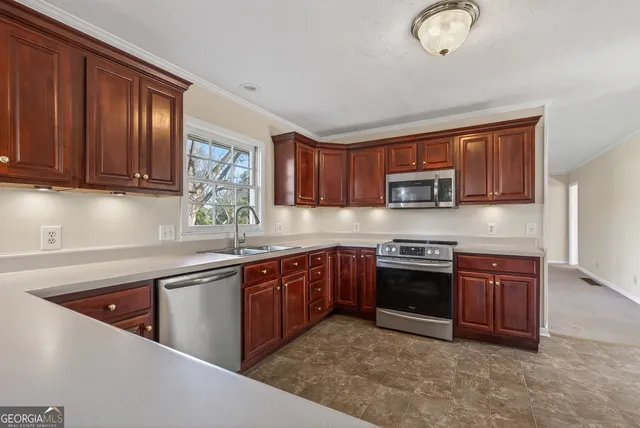 a kitchen with stainless steel appliances granite countertop wooden cabinets a stove top oven a sink and dishwasher