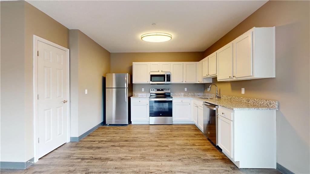 1450 Fifth Avenue, Unit 300 Pittsburgh, PA 15219 - Photo 16 of 24 a kitchen with stainless steel appliances granite countertop a refrigerator and a stove top oven