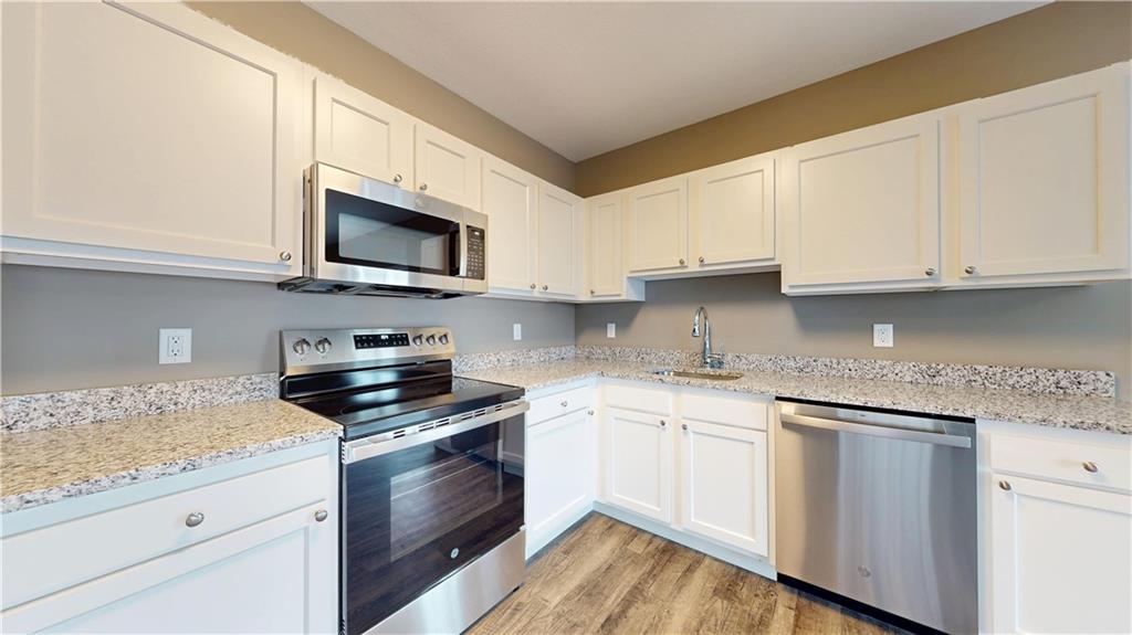 1450 Fifth Avenue, Unit 300 Pittsburgh, PA 15219 - Photo 17 of 24 a kitchen with granite countertop wooden cabinets and a stove top oven