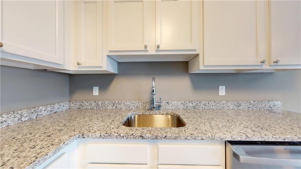 1450 Fifth Avenue, Unit 300 Pittsburgh, PA 15219 - Photo 18 of 24 a kitchen with granite countertop a sink and a white cabinets