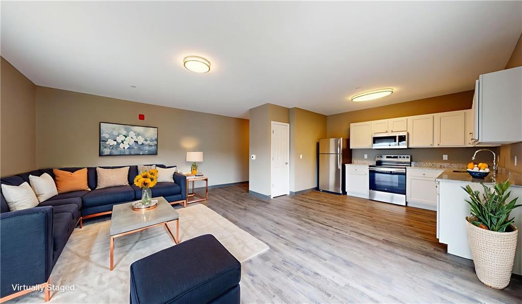 1450 Fifth Avenue, Unit 300 Pittsburgh, PA 15219 - Photo 23 of 24 a living room with furniture and kitchen view with wooden floor