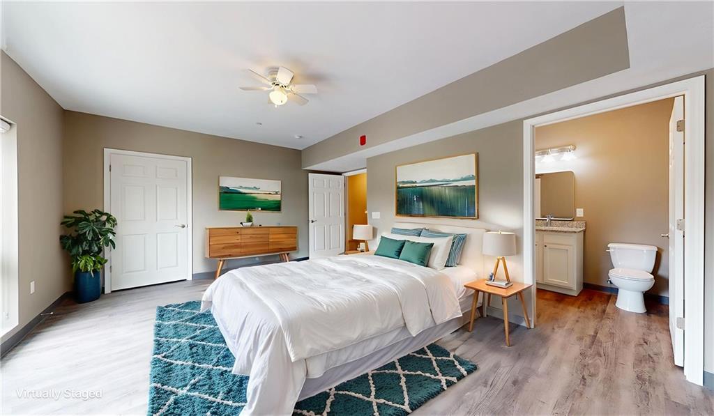 1450 Fifth Avenue, Unit 300 Pittsburgh, PA 15219 - Photo 7 of 24 a spacious bedroom with a bed and a chandelier