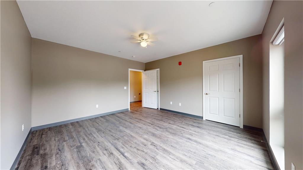 1450 Fifth Avenue, Unit 300 Pittsburgh, PA 15219 - Photo 9 of 24 a view of an empty room with wooden floor and a ceiling fan