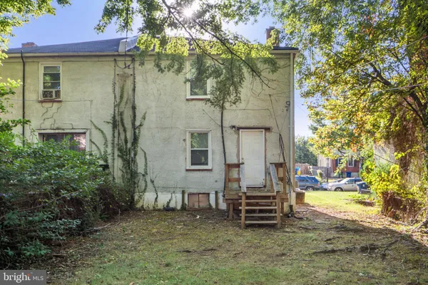 a backyard of a house with barbeque oven and trees