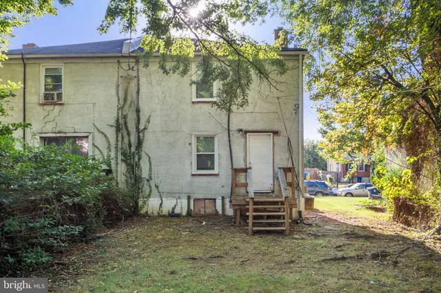 a backyard of a house with barbeque oven and trees