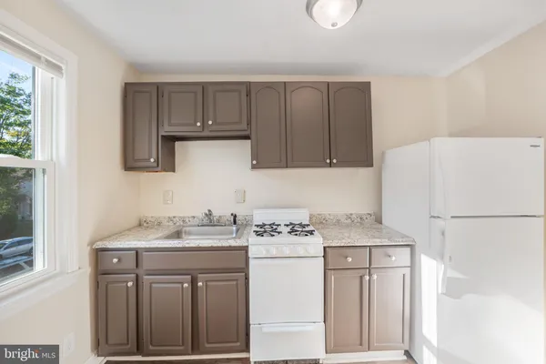 a kitchen with stainless steel appliances granite countertop a sink stove and white cabinets