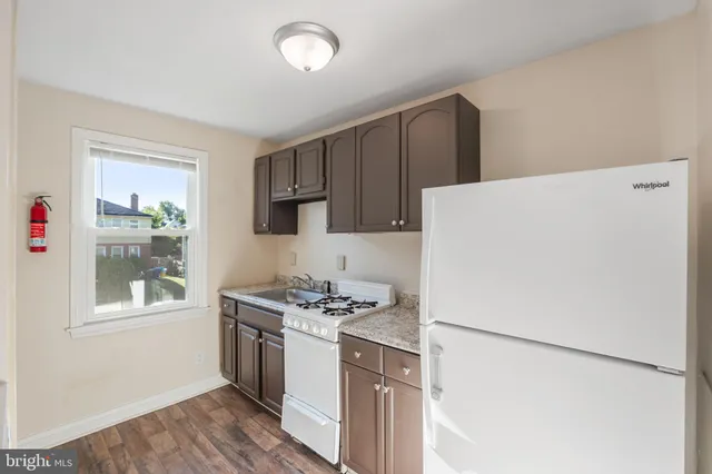 a kitchen with a stove a refrigerator and a window