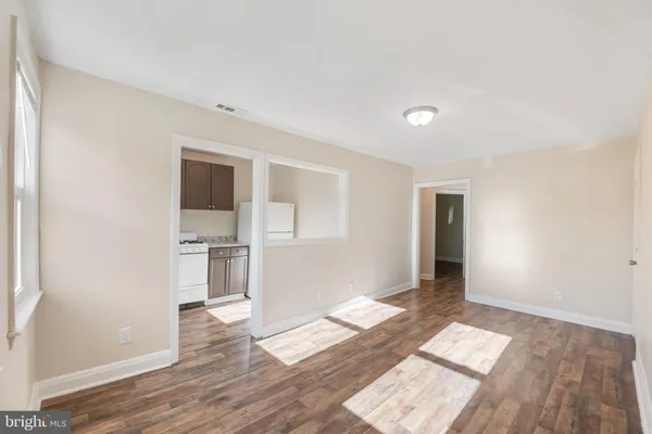 a view of empty room with wooden floor