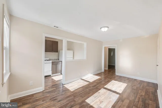 a view of empty room with wooden floor